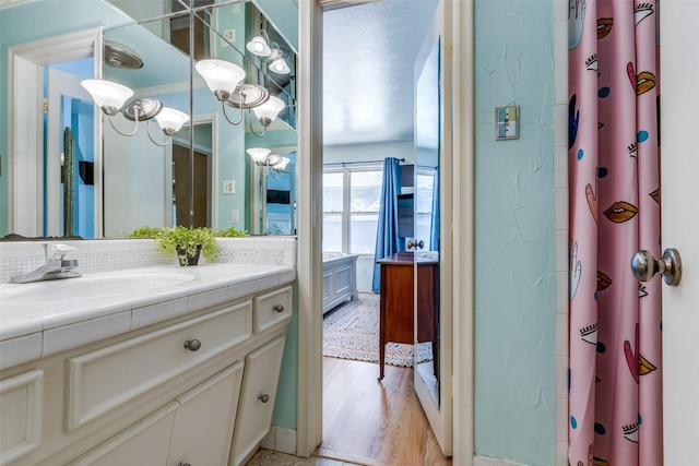 bathroom featuring curtained shower, vanity, and wood finished floors