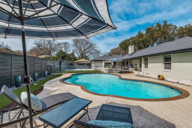 view of swimming pool featuring a fenced backyard, a fenced in pool, and a patio