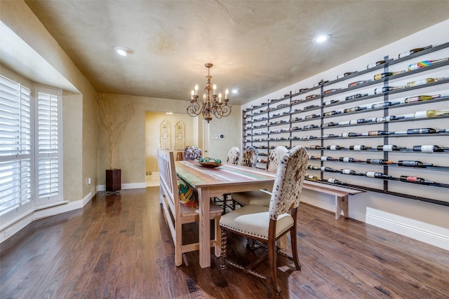 dining area featuring a notable chandelier, baseboards, wood finished floors, and recessed lighting