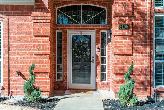 entrance to property featuring brick siding