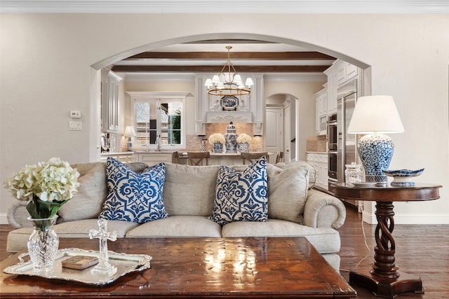 living area featuring a chandelier, arched walkways, wood finished floors, and crown molding