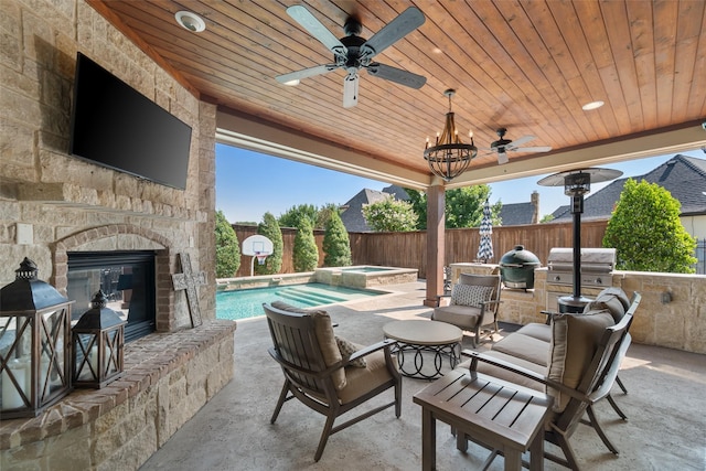 view of patio with an outdoor stone fireplace, fence, grilling area, and ceiling fan