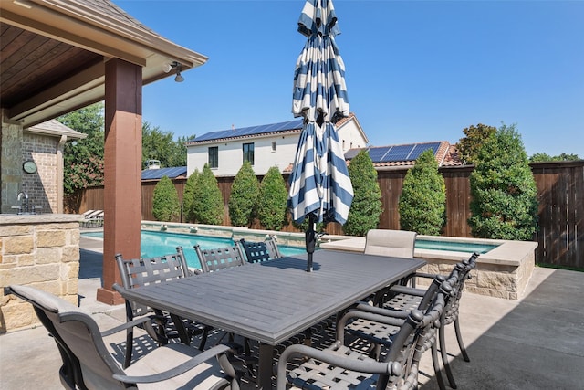 view of patio featuring outdoor dining area, a fenced backyard, and a fenced in pool