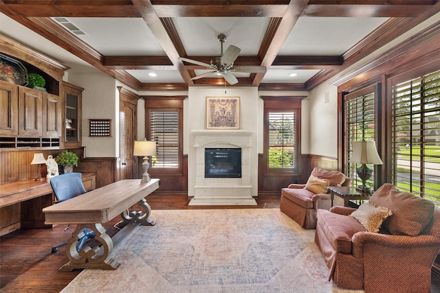 interior space featuring wainscoting, a fireplace, beamed ceiling, and wood finished floors