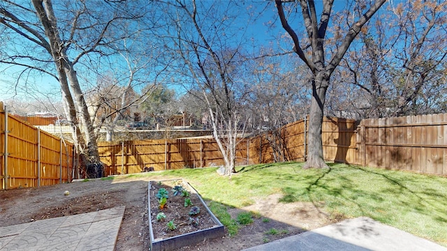 view of yard featuring a fenced backyard and a garden