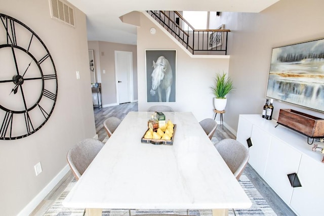 dining space with visible vents, baseboards, and wood finished floors