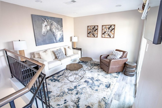 living area featuring baseboards, wood finished floors, visible vents, and recessed lighting