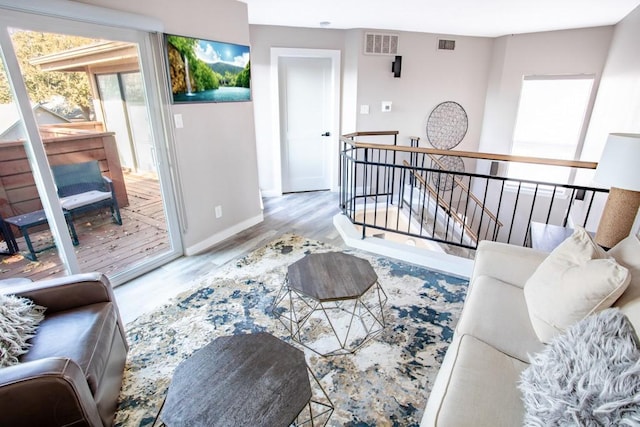 living area with visible vents, baseboards, and wood finished floors