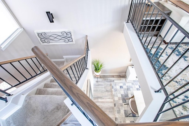 staircase with baseboards and wood finished floors