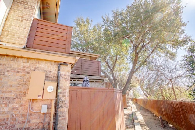 view of home's exterior featuring brick siding and fence