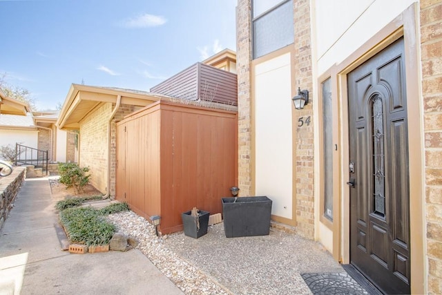 doorway to property featuring brick siding