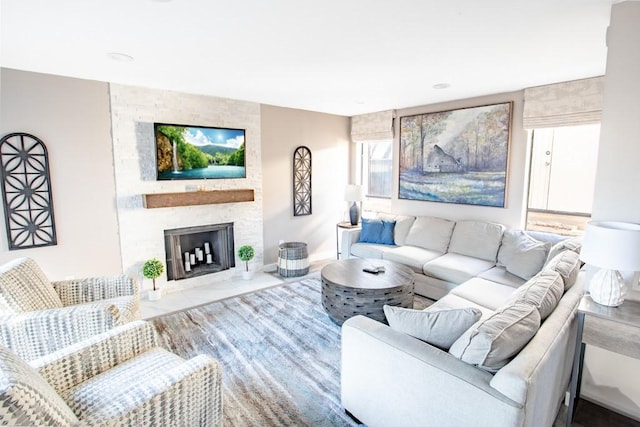 living room featuring a large fireplace and baseboards