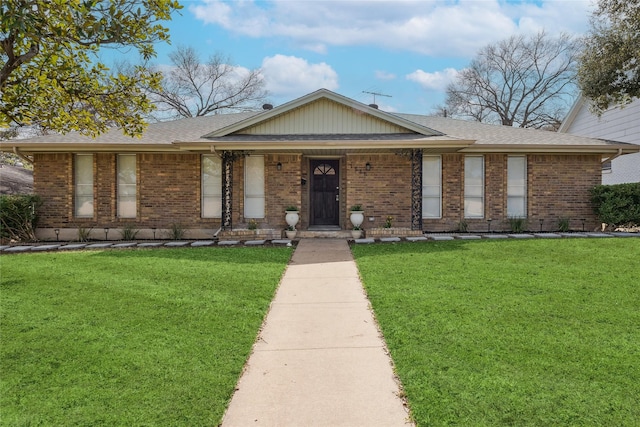 single story home with a porch, a front yard, brick siding, and roof with shingles