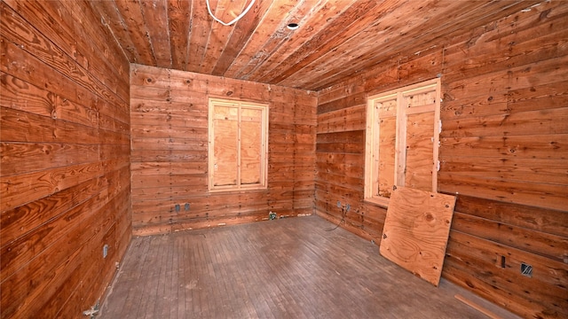 empty room featuring wooden ceiling, wood walls, and wood finished floors