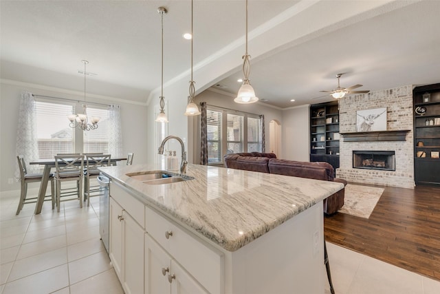 kitchen with a wealth of natural light, built in shelves, ornamental molding, and a sink