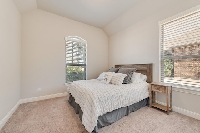 bedroom with lofted ceiling, light carpet, and baseboards