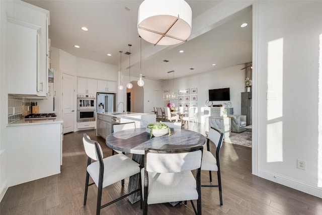 dining space featuring baseboards, dark wood-type flooring, a chandelier, and recessed lighting