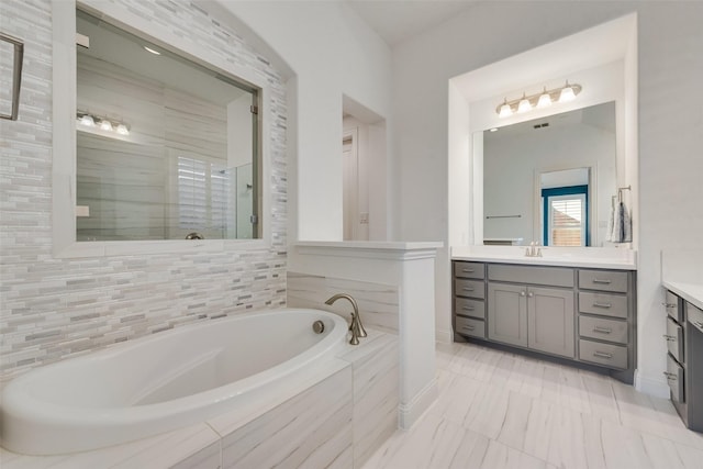 full bathroom featuring vanity, a shower stall, and a bath