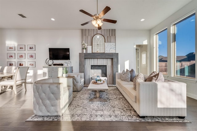 living room featuring recessed lighting, visible vents, a fireplace, and wood finished floors