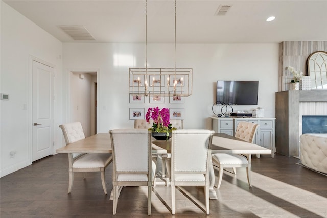 dining space featuring dark wood-type flooring, visible vents, and an inviting chandelier