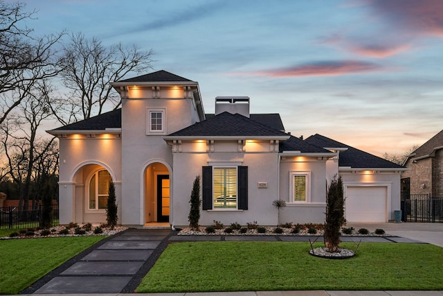 view of front of property with driveway, a front yard, fence, and stucco siding