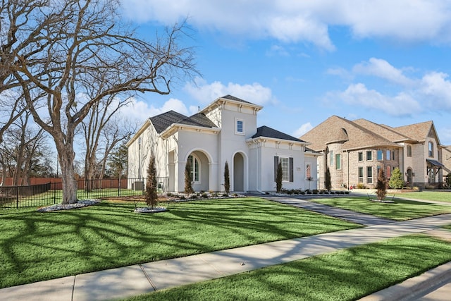 view of front facade featuring fence, a front lawn, and stucco siding