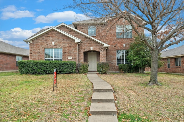 traditional-style home with brick siding and a front yard