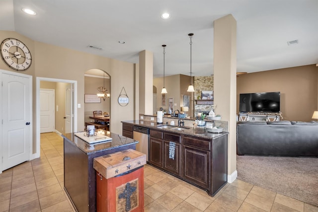 kitchen featuring a center island, arched walkways, visible vents, stainless steel dishwasher, and a sink