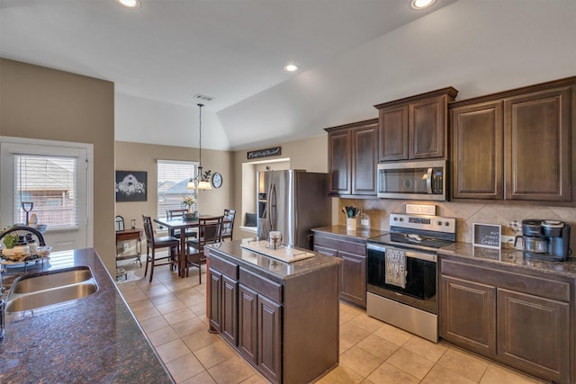 kitchen with visible vents, vaulted ceiling, dark brown cabinets, stainless steel appliances, and a sink