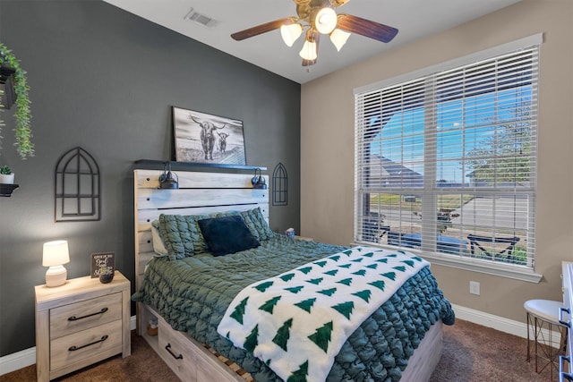 bedroom with dark colored carpet, visible vents, ceiling fan, and baseboards