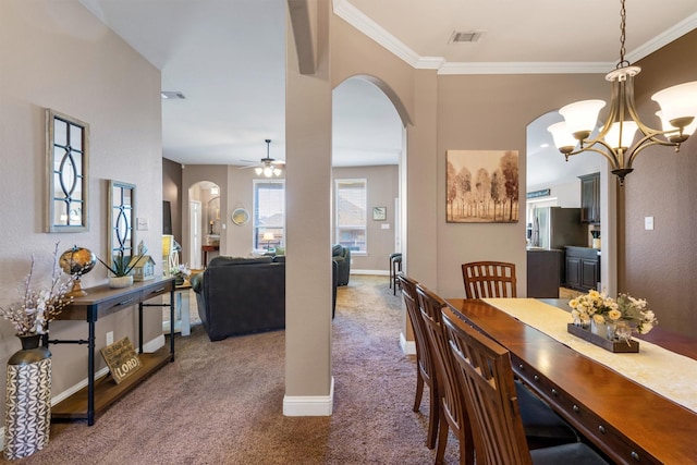 dining area with carpet floors, arched walkways, crown molding, and baseboards