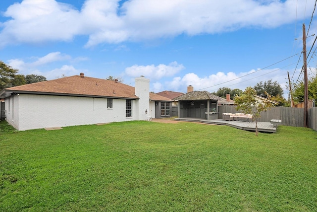 back of house with a fenced backyard, a chimney, an outdoor hangout area, a yard, and a wooden deck