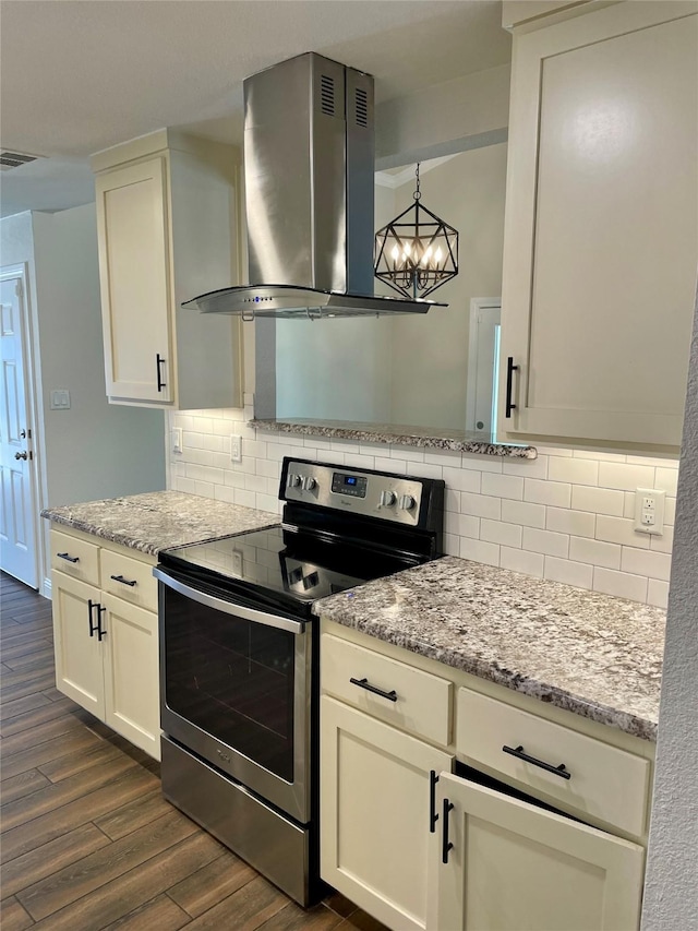 kitchen with dark wood-style floors, visible vents, stainless steel electric range oven, wall chimney exhaust hood, and tasteful backsplash