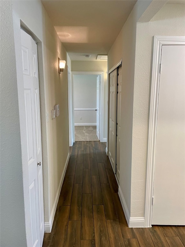 hall featuring dark wood-style floors and baseboards