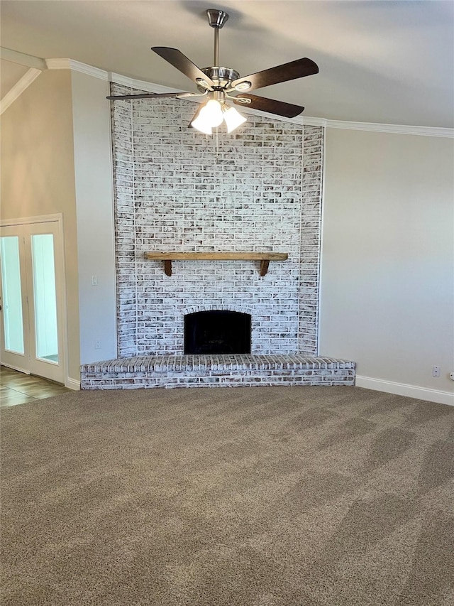 unfurnished living room with a brick fireplace, carpet, ornamental molding, and ceiling fan