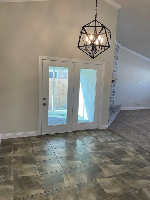 doorway featuring french doors, a notable chandelier, ornamental molding, high vaulted ceiling, and baseboards