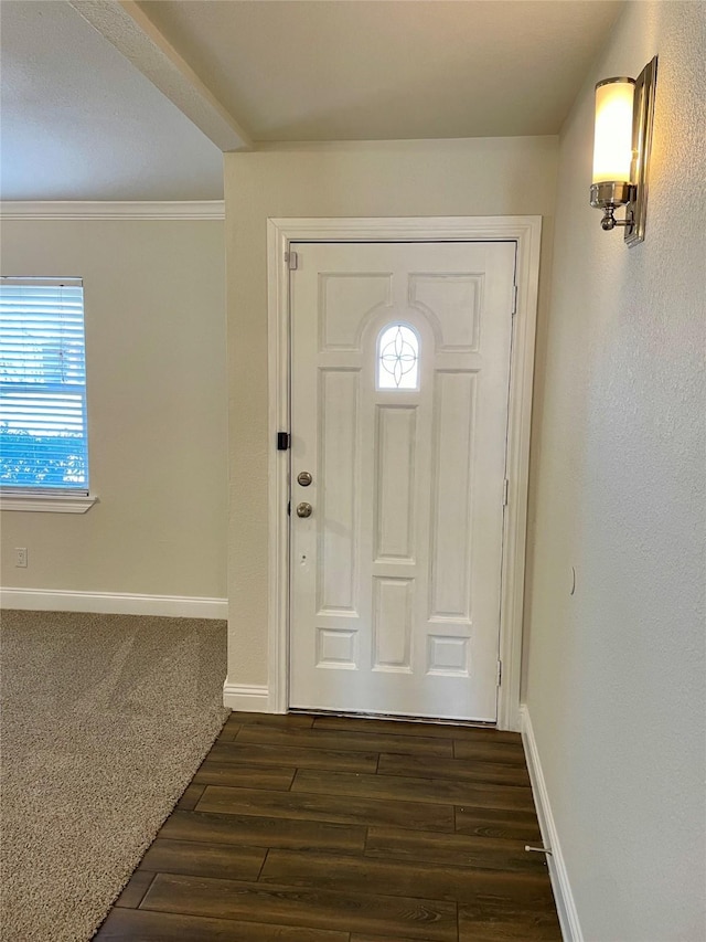 entryway featuring dark wood-style floors, crown molding, and baseboards