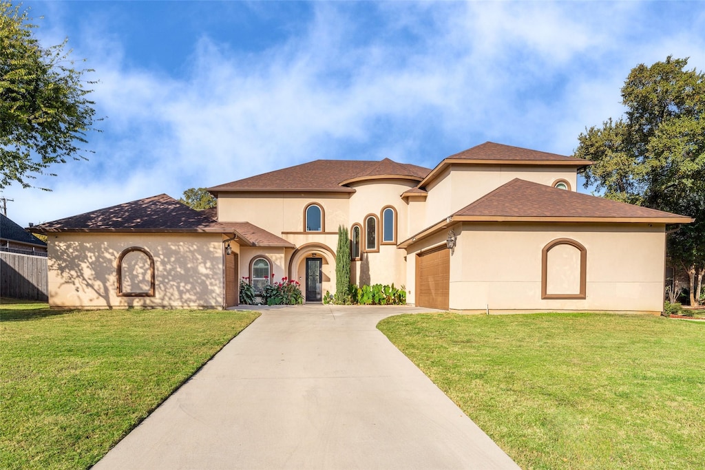 mediterranean / spanish-style house featuring driveway, an attached garage, a front lawn, and stucco siding