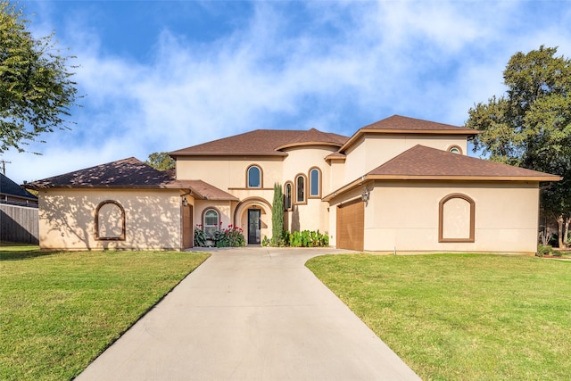 mediterranean / spanish-style house featuring driveway, an attached garage, a front lawn, and stucco siding