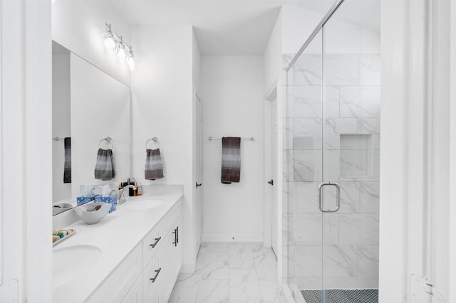 full bath featuring marble finish floor, a shower stall, baseboards, and a sink