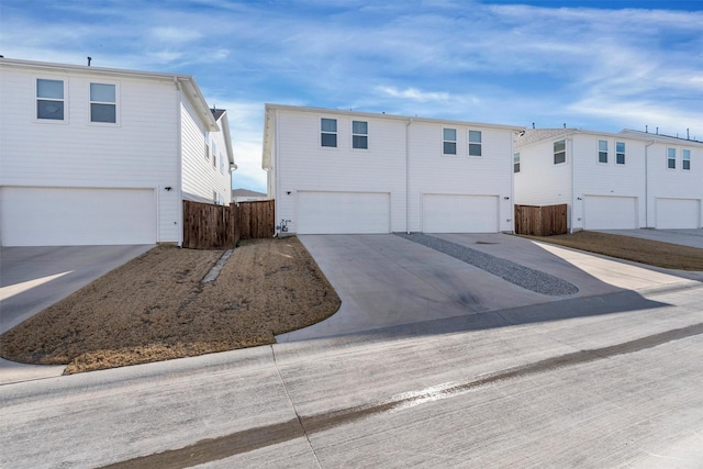 view of front of property featuring fence, driveway, and an attached garage