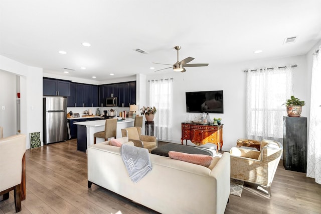 living area featuring light wood-type flooring, plenty of natural light, and visible vents