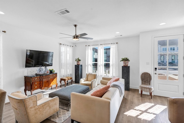 living area featuring a ceiling fan, visible vents, wood finished floors, and recessed lighting