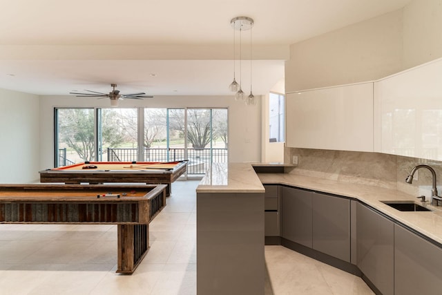 game room with light tile patterned floors, ceiling fan, and a sink