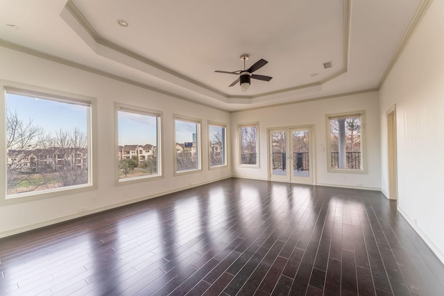 unfurnished sunroom featuring a ceiling fan, a tray ceiling, french doors, and visible vents