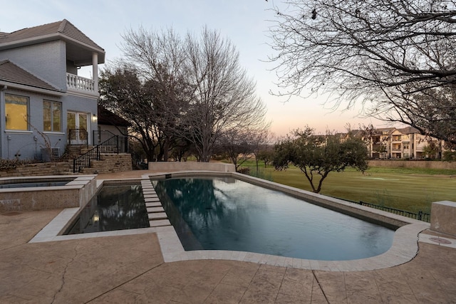 outdoor pool featuring stairs, an in ground hot tub, a lawn, and a patio area