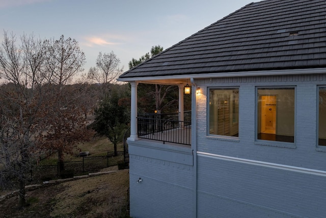 property exterior at dusk with brick siding and fence