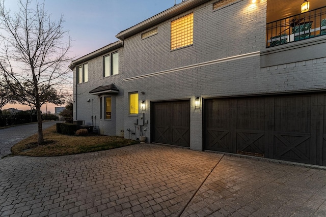 view of front of property with a garage, decorative driveway, and brick siding