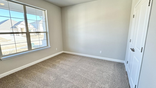 carpeted spare room with baseboards