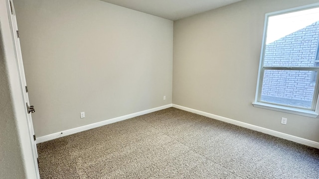 spare room with carpet and baseboards